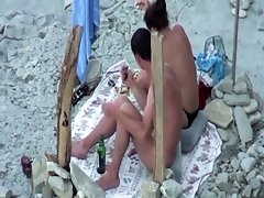 Raven haired chick was caught sucking her man at the beach on spy cam