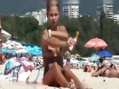 Une fille aux seins nus a la plage est espionnee devant une camera voyeur